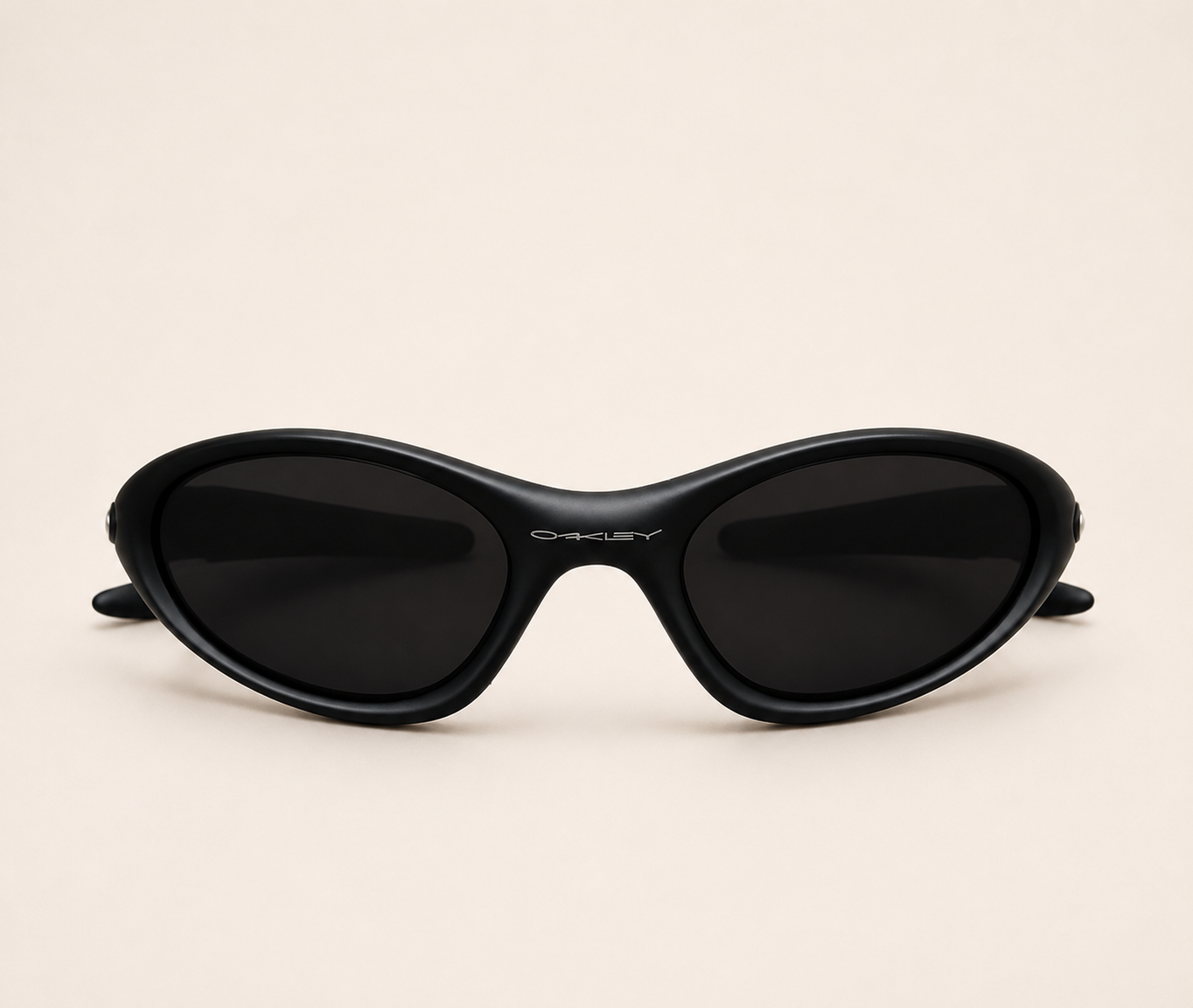 Front view of black Oakley Minute sunglasses with dark lenses and a curved wraparound frame.